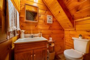 een badkamer met een toilet en een wastafel in een blokhut bij Quiet Way Cabin By Avada Properties in Sevierville +24 foto's