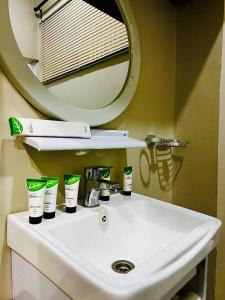 a bathroom sink with toothbrushes and a mirror at The Dawn cottage in Moshi