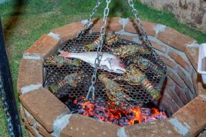 a group of lobsters cooking over a fire at Pousada no Mar in Icaraí