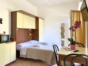 een slaapkamer met een bed en een tafel met stoelen bij Residence Carioca in Rimini