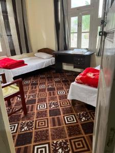 a room with two beds and a table and a floor at K6 Hotel & Camping Kande in Kande