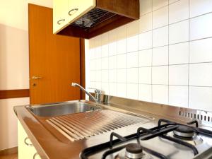 een keuken met een roestvrijstalen wastafel en een fornuis bij Residence Carioca in Rimini