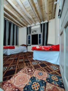 a room with two beds and a rug on the floor at K6 Hotel & Camping Kande in Kande