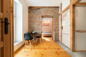 a room with a brick wall and a table and chairs at Premium Basement Apartament by Vibe Hostel in Sopot