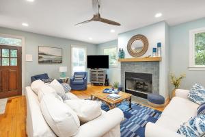 a living room with white couches and a fireplace at 1104 Demere Road in Saint Simons Island