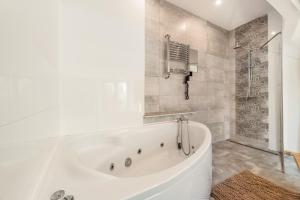 a white tub in a bathroom with a shower at Premium Basement Apartament by Vibe Hostel in Sopot