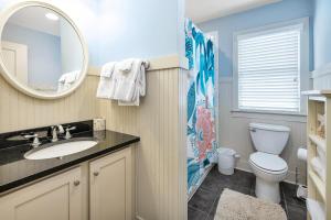 a bathroom with a toilet and a sink and a mirror at 1104 Demere Road in Saint Simons Island +31 photos