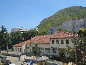 a building with a mountain in the background at Pansion Most , Mostar in Mostar