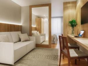 un soggiorno con divano bianco e specchio di Golden Tulip Canela a Canela