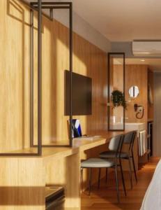 una camera da letto con scrivania, sedie e TV di Golden Tulip Canela a Canela