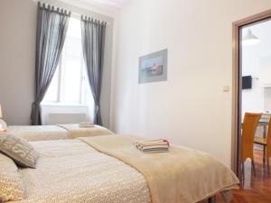 a bedroom with two beds and a window at Apartman Draguć in Pula