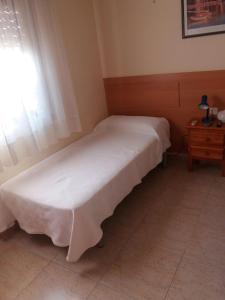 uma cama individual num quarto com uma janela em Hostal Jose Luis em Brunete
