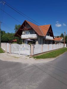une clôture blanche devant une maison dans l'établissement Apartment Balatonkeresztur - Balaton 19286, à Balatonkeresztúr