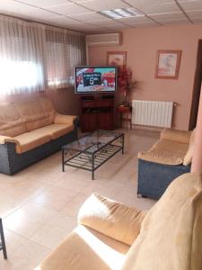uma sala de estar com dois sofás e uma televisão em Hostal Jose Luis em Brunete