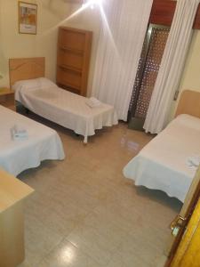 una habitación de hotel con 2 camas en una habitación en Hostal Jose Luis, en Brunete