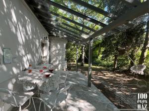 a patio with a table and chairs under a pergola at 100 éves ház in Balatonakarattya