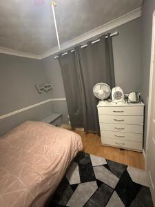 a bedroom with a bed and a dresser in it at Double room in a shared house in Chatham