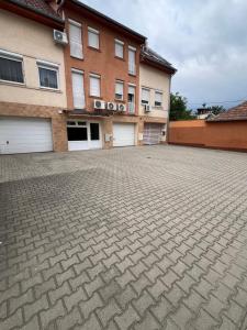 a brick parking lot in front of a building at GOLD-LUX Apartman Nyíregyháza in Nyíregyháza