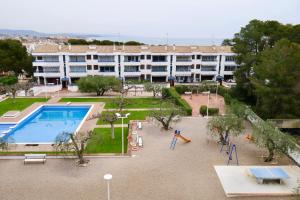 an apartment building with a pool and a playground at Apartamento con piscina in Torredembarra