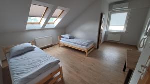 a bedroom with a bed and a couch and windows at Hostel Centrum in Końskie