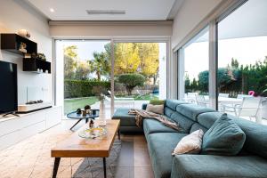 Una sala de estar con un sofá verde y una ventana grande. en 2HomeRent Las Colinas, en Orihuela Costa