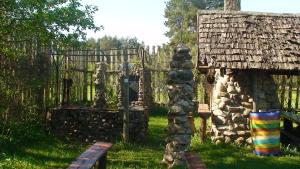 a garden with a gate and a stone building at Tammekännu Holiday House in Mammaste