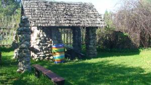 a small stone building with a bench in front of it at Tammekännu Holiday House in Mammaste