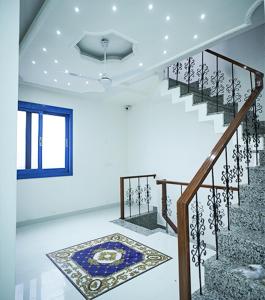 a staircase in a house with a window and a rug at The Host By Amaris in Amritsar