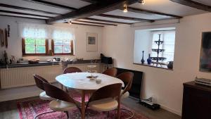 a dining room with a table and chairs at Urgemütlicher Winkelhof "La ferme von 1634" mit Terrasse in Simmerath