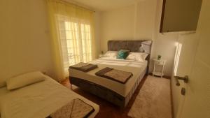 a small bedroom with two beds and a window at Apartman Obala in Čapljina