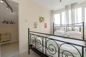 a bedroom with a wrought iron bed with a window at Charming Edinburgh Bungalow KEYWORKERS BUSINESS 10MIN TO THE HOSPITAL in Edinburgh