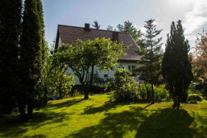 a house in a garden with trees and grass at Willa Bartek in Ciechocinek