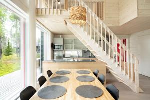 a dining room with a table and a staircase at 2-Wing Villa 4BR, 2 SkiPasses, Ylläs & Nature View in Ylläsjärvi
