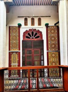 a building with a balcony with a door and windows at Riad Ayoub Fes in Fès +66 photos