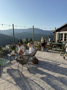a group of people sitting in chairs on a patio at Bílá Labuť Pec in Pec pod Sněžkou