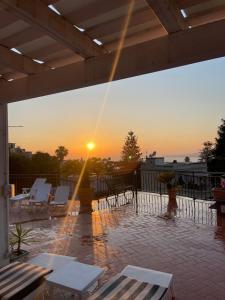 a sun setting on a patio with chairs and tables at La Terrazza Quisisana Sorrento Coast in Castellammare di Stabia