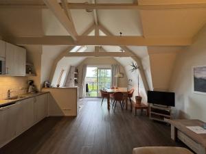 a kitchen with a table and a dining room at Herenstraat 55 in Den Hoorn