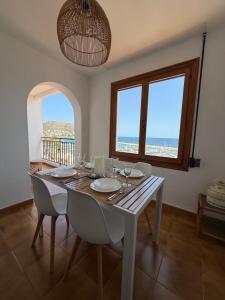 a dining room with a table with a view of the ocean at Apartamento Sal Marina in Moraira