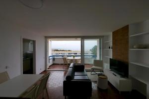 a living room with a couch and a large window at Apartamento con piscina in Torredembarra