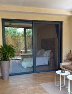 a bedroom with a bed outside of a glass door at Villa YEMAYA - Suite bungalow indépendant in Ngaparou