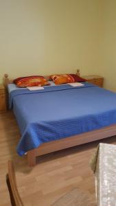 a bedroom with a blue bed with two pillows at Harley 1 Oder 6 in Karlobag