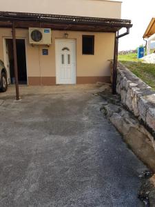 a house with a white door and a stone wall at Harley 1 Oder 6 in Karlobag