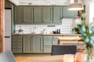 a kitchen with green cabinets and a table at Marstrand in Marstrand