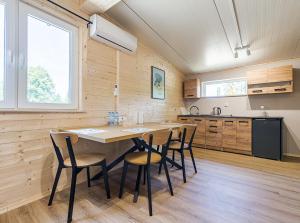 a kitchen with a large wooden table and chairs at Domki Nad Potokiem in Wańkowa