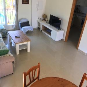 a living room with a television and a table at Villa garden and sea in Alicante
