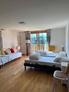 a large bedroom with two beds and a large window at PetitChevrier - 6BR Spacious Chalet in Villars - Designed for Accessibility in Ollon