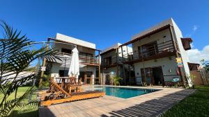 a villa with a swimming pool and a house at Jangadas do Toque Milagres Flats no Térreo in São Miguel dos Milagres