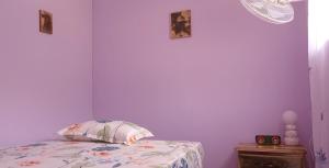 a bedroom with purple walls and a bed with a pillow at Mystic Moment in Negril