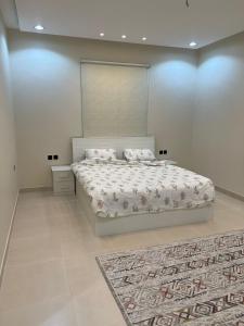 a bedroom with a large bed and a rug at شقق روابي الباحه in Al Jith