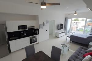 a white living room with a bed and a couch at Costa Paraíso D-9 Estudio in Bucerías